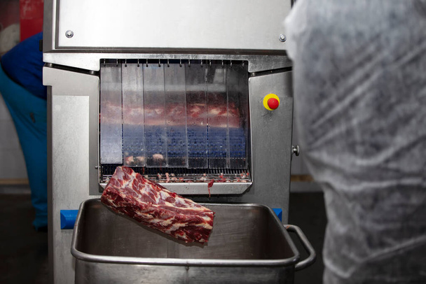 Máquina industrial em uma fábrica de carne para cortar pedaços de carne. - Foto, Imagem
