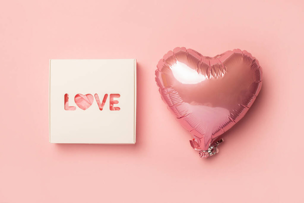 Caja de regalo y globo aerostático sobre fondo rosa pastel. Composición Día de San Valentín. Asiento plano, vista superior. Banner. - Foto, imagen