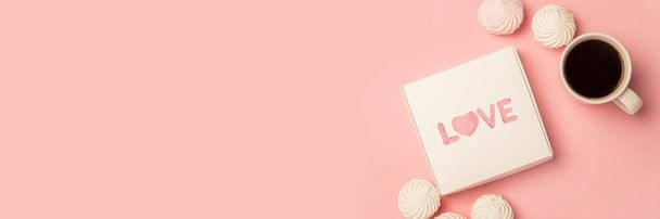 Gift box, cup with coffee, meringue and sweets on a pink background. Composition Valentine's Day. Banner. Flat lay, top view. - Photo, Image