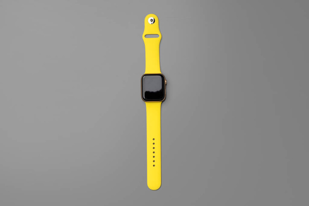 Yellow smartwatch on gray background close up - Фото, изображение
