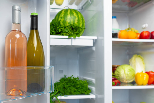 Open fridge full of fruits, vegetables and drinks - Фото, изображение