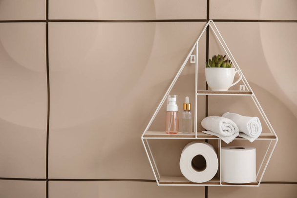 Moderne plank met lichaamsverzorging cosmetica en accessoires op kleur muur in de badkamer - Foto, afbeelding