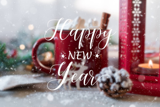 Szczęśliwego Nowego Roku Tekst z zimowym gorącym napojem, kakao z piankami i cynamonem lub pikantna gorąca czekolada w czerwonym kubku i świąteczne lampki girlandowe. Uroczysta kartka okolicznościowa - Zdjęcie, obraz