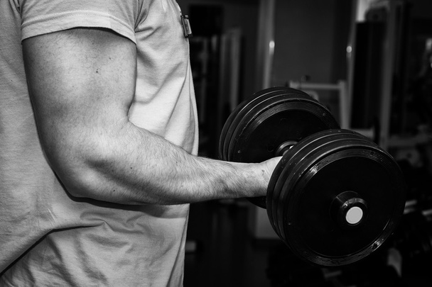 Man doing exercises with dumbbell in the gym - Photo, Image