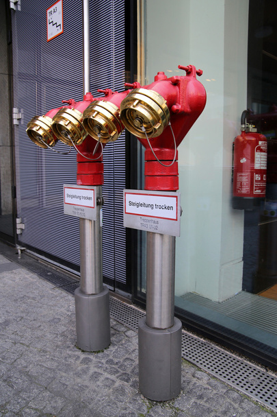 001 Shiny metal red water plug with seals and plugs on the street, Красный блестящий металлический пожарный кран  с пломбами и затычками на улице - Fotografie, Obrázek