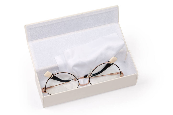 Сучасні окуляри для жінок в металевому жовтому фланці лежать у білій жорсткій виставковій коробці з окулярами протирати на білому тлі
 - Фото, зображення