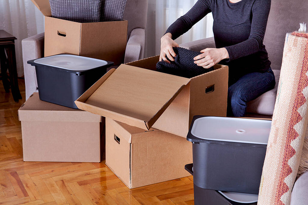 The woman is moving to a new house. Boxes are moved to the new house. Real estate concept. - Photo, Image