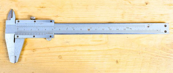caliper with centimeter and millimeter on wooden bench - Photo, Image