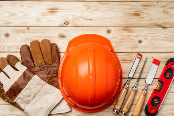 Construction worker tools hardhat and chisel on wooden background - 写真・画像