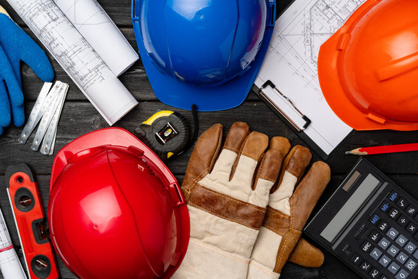 Hardhat, gloves and blueprints of a builder - Фото, изображение