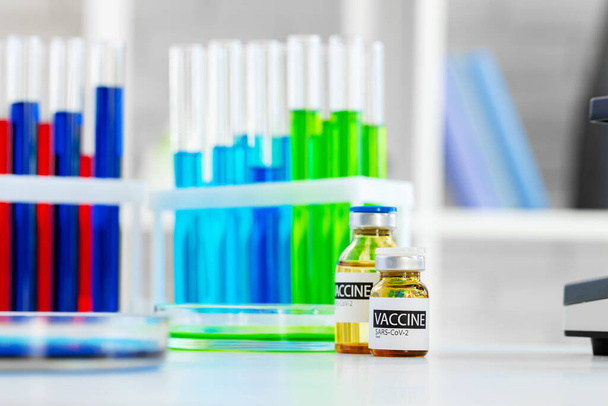 Vaccine in vial for injection on table against background of laboratory - Zdjęcie, obraz