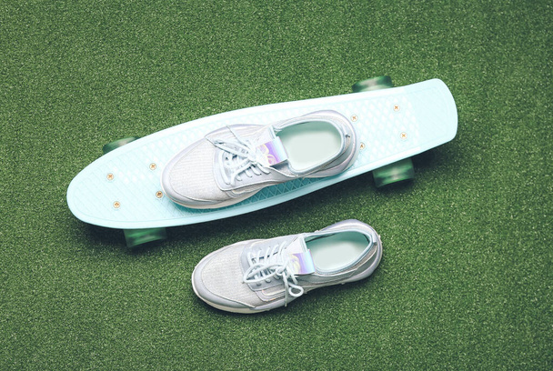 Спортивне взуття та скейтборд на кольоровому фоні
 - Фото, зображення