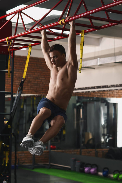 Handsome muscular man training in gym - Фото, изображение