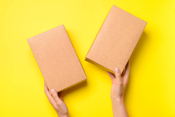 Hands with cardboard boxes on color background - Photo, Image
