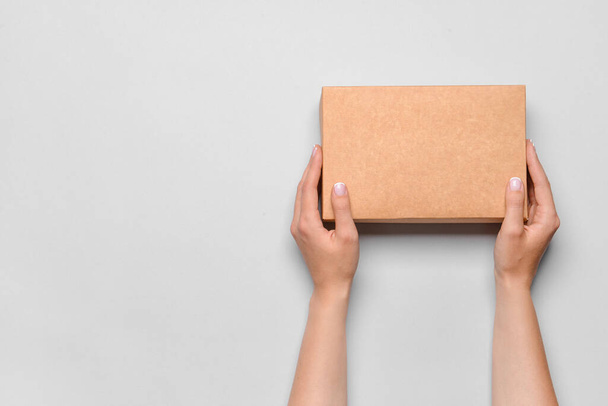 Hands with cardboard box on white background - Photo, Image
