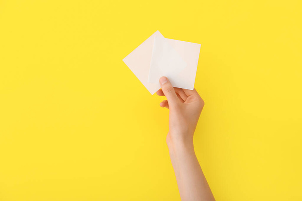 Женская рука с чистыми бумажками на цветном фоне - Фото, изображение