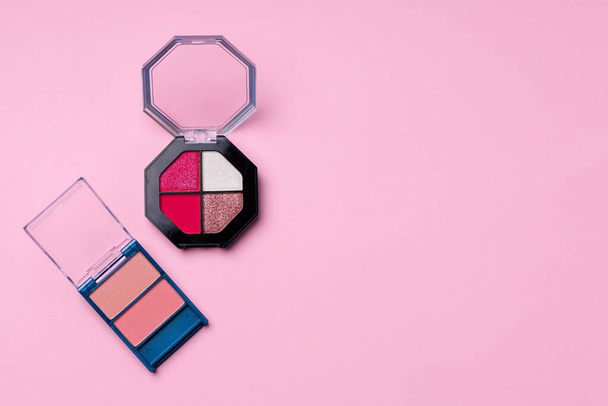 Set of eyeshadows make up products on pink - Photo, image