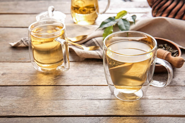 Σύνθεση με φλυτζάνια πράσινο τσάι σε ξύλινο τραπέζι - Φωτογραφία, εικόνα