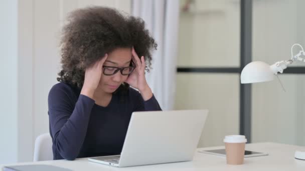 Mujer africana con dolor de cabeza mientras usa el ordenador portátil  - Imágenes, Vídeo