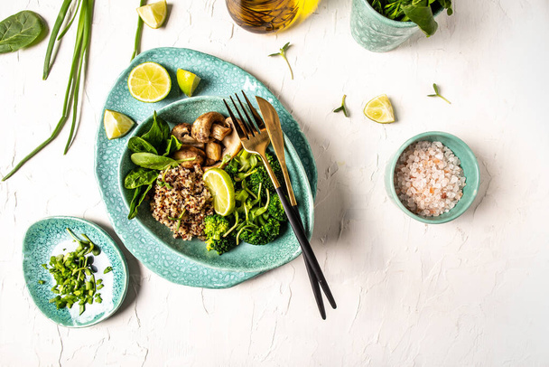 Diétás saláta friss zöldségbrokkoliból, gombából, spenótból és quinoából egy tálban. Finom reggeli vagy snack, tiszta evés, diéta, vegán étel koncepció. függőleges kép - Fotó, kép