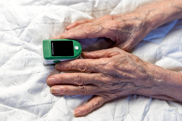 Assessment of the respiratory system function. measurement of blood saturation and pulse in an elderly patient using a pulse oximeter. health and medicine - Foto, Bild