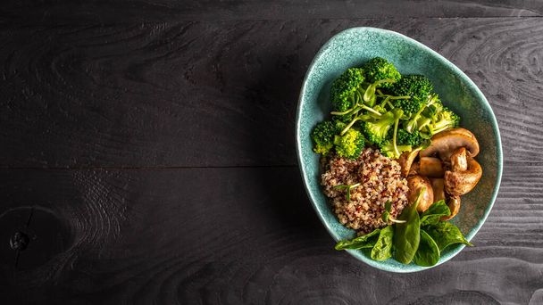 Dietní salát z čerstvé zeleninové brokolice, hub, špenátu a chinoy v misce. Lahodná snídaně nebo svačinka, Čisté jídlo, dieta, veganské jídlo koncept. svislý obrázek - Fotografie, Obrázek