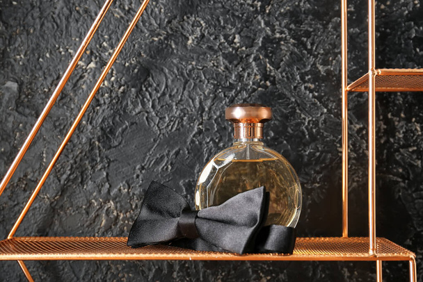 Botella de perfume y corbata sobre fondo oscuro - Foto, Imagen
