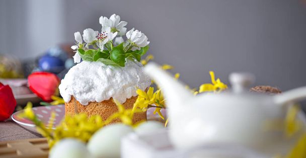 Ev yapımı Paskalya pastası masanın üzerinde, çiçeklerin arasında fotokopi alanının arasında. Evde Paskalya tatili konsepti. - Fotoğraf, Görsel
