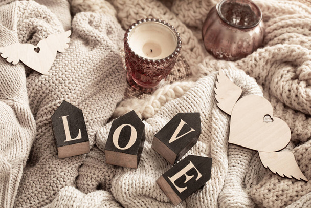 Las letras de madera componen la palabra amor sobre un fondo de elementos de punto acogedor. Día de San Valentín concepto de vacaciones. - Foto, Imagen