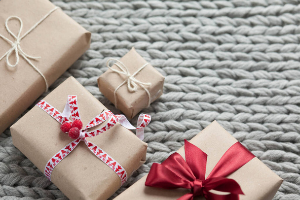Geschenkschachteln mit Bändern auf gestricktem Hintergrund. Weihnachts- und Neujahrsgeschenke. Geburtstagsgrüße und Geschenke. - Foto, Bild