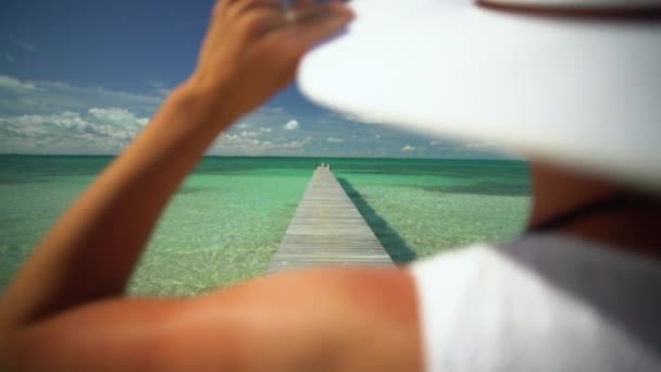 Mladá žena s bílým kloboukem na molu Bahamy - Záběry, video