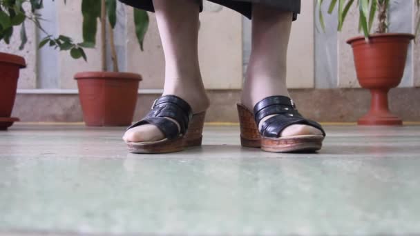 Női láb papucsban fordul a kamera előtt közelkép - Felvétel, videó