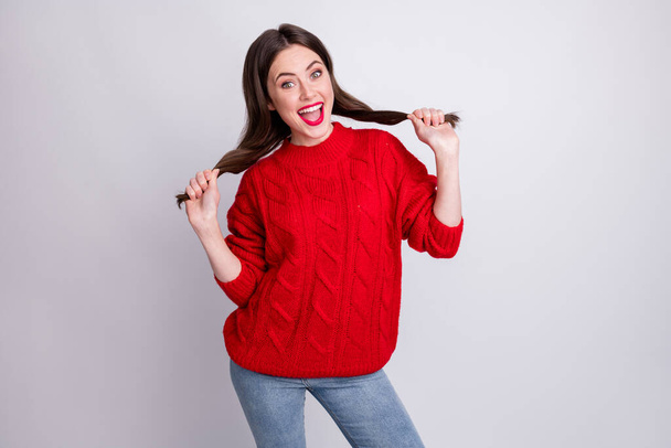 Photo portrait of careless childish girl keeping hair tails funny red knitted sweater smiling isolated on pastel grey color background - Foto, afbeelding