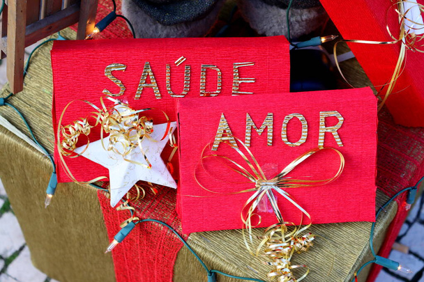 Rote Geschenkboxen mit goldenen Bändern und portugiesischen Wörtern wie "Liebe" und "Gesundheit"" - Foto, Bild