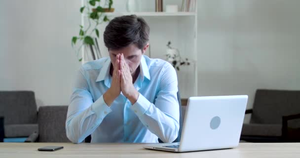 Shocked frustrated caucasian millennial business man student feel stressed look at computer screen worried of problem read bad online news receive failed exam results concept sit at home office table - Footage, Video