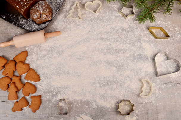 Pâte crue de pain d'épice et coupeurs pour biscuits de Noël sur la table de farine blanche de cuisine. Espace de copie. Préparez des biscuits au pain d'épice de Noël. 2021 - Photo, image