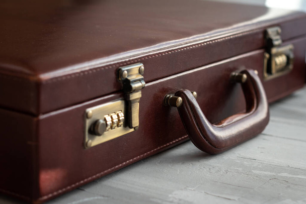 maleta marrón vintage vista de cerca sobre un fondo gris - Foto, imagen