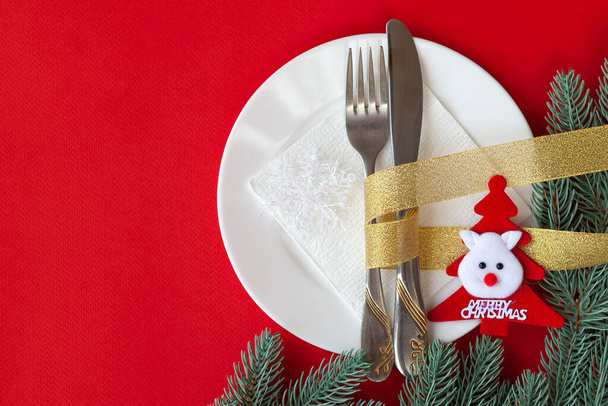 Σερβίρεται χριστουγεννιάτικο τραπέζι γδαρμένο με διακοσμητικά σύμβολα σε κόκκινο φόντο - Φωτογραφία, εικόνα