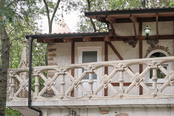 Altbaubalkon. Haus im klassischen Stil in einem Park. Balkon mit Dekoration. Villa mit kleinen Fenstern. - Foto, Bild