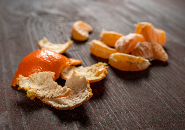 Mandarin slices on a dark wooden background - Photo, Image