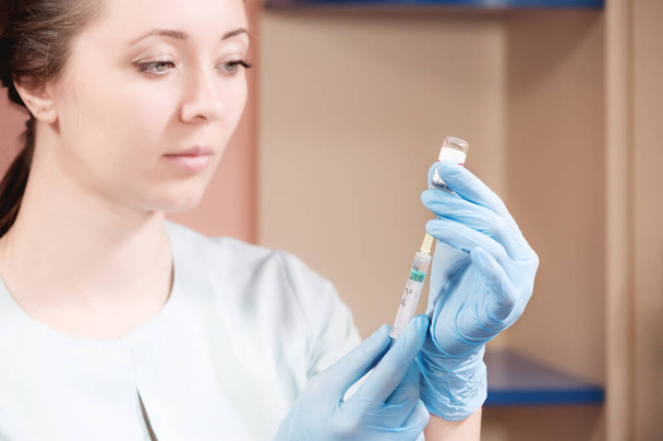 Woman doctor beautician picks up liquid into a syringe for injection rejuvenation - Fotoğraf, Görsel