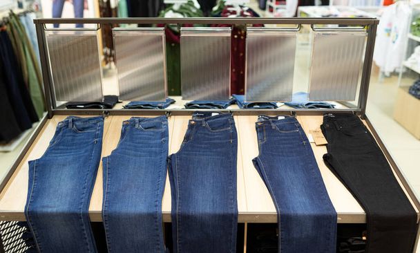 muchos pantalones y jeans se cuelgan en los grandes almacenes - Foto, Imagen
