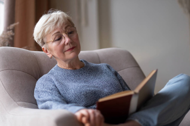 Starší běloška doma čte knížku - Fotografie, Obrázek
