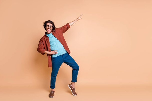 Full length photo of guy indicate finger up open mouth wear specs brown t-shirt pants shoes isolated beige color background - Φωτογραφία, εικόνα
