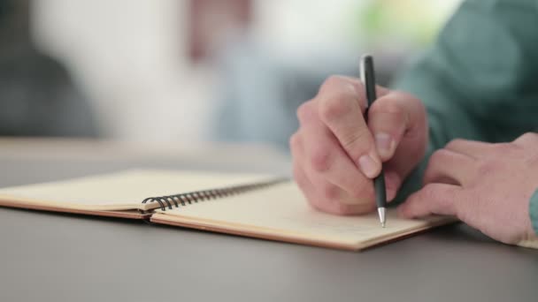 Κοντινό πλάνο του Hands of Man Writing στο Notebook - Πλάνα, βίντεο