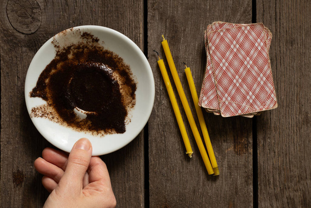 coffee grounds on a saucer for fortune telling cards and candles on the table, fortune telling on coffee grounds - Photo, Image