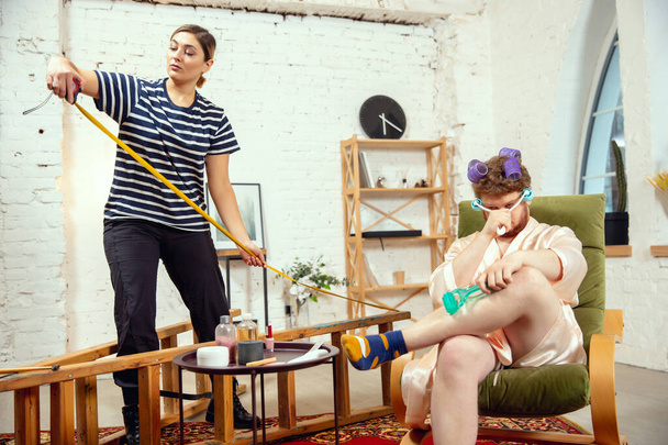 Gender stereotypes. Wife and husband doing things unusual for their genders in social meanings - Photo, Image