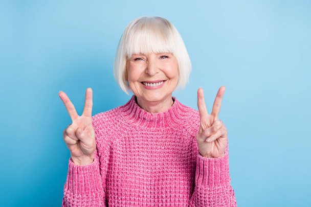 Photo portrait of happy old lady showing two v-signs isolated on pastel blue colored background - Photo, image
