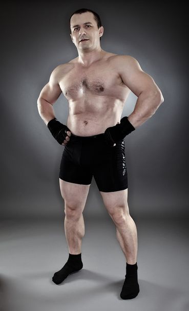Shirtless athletic muscular man standing akimbo - 写真・画像