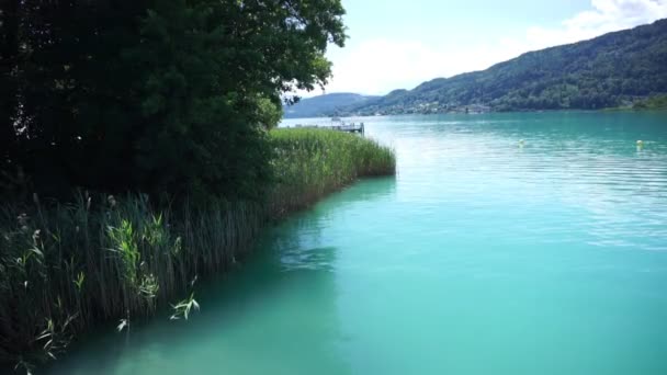 Lake Worthersee lähellä Klagenfurt Itävallassa kauniina aurinkoisena päivänä - Materiaali, video